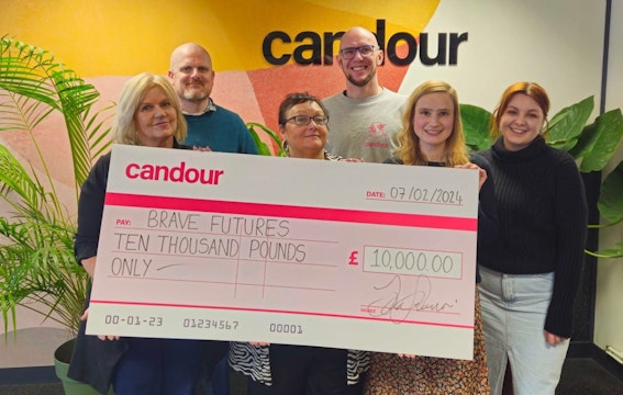 Colleagues from Candour and Brave Futures holding a large cheque for £10,000 which is a donation to Brave Futures